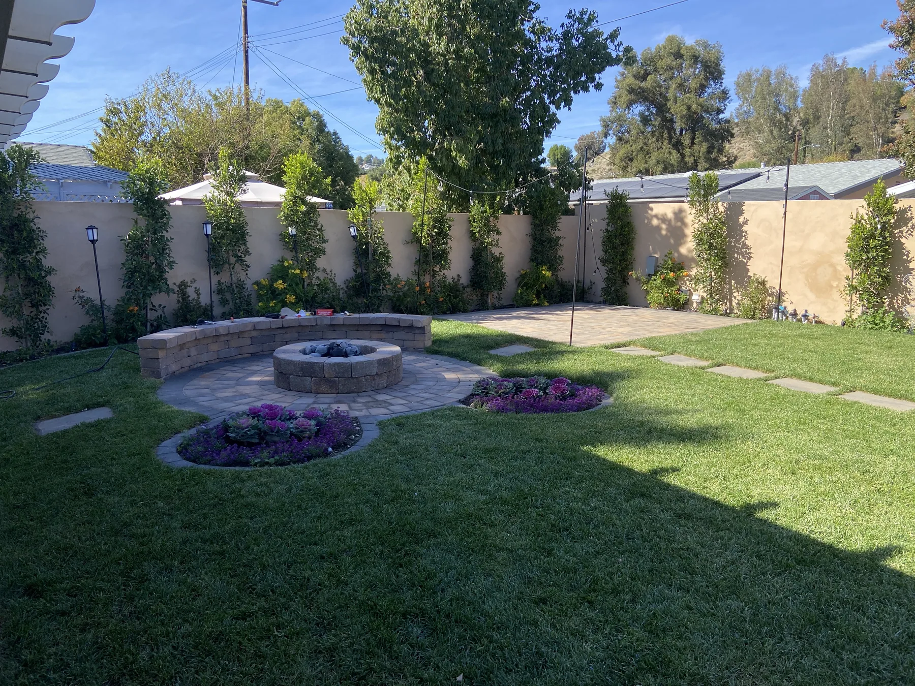 Finished backyard with fire pit seating and turf lawn