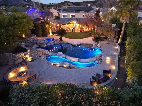 Resort-style backyard with freeform pool and fire pit