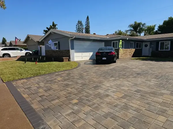 Paver driveway with a stone accent house
