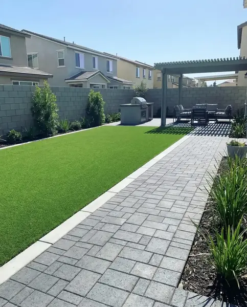 Paver walkway and patio with a pergola and built in barbecue