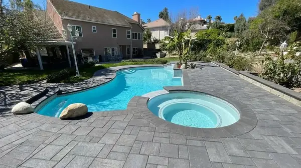 Pool and spa surrounded by paver decking