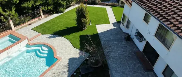 Elevated view of a pool with paver decking and turf lawns